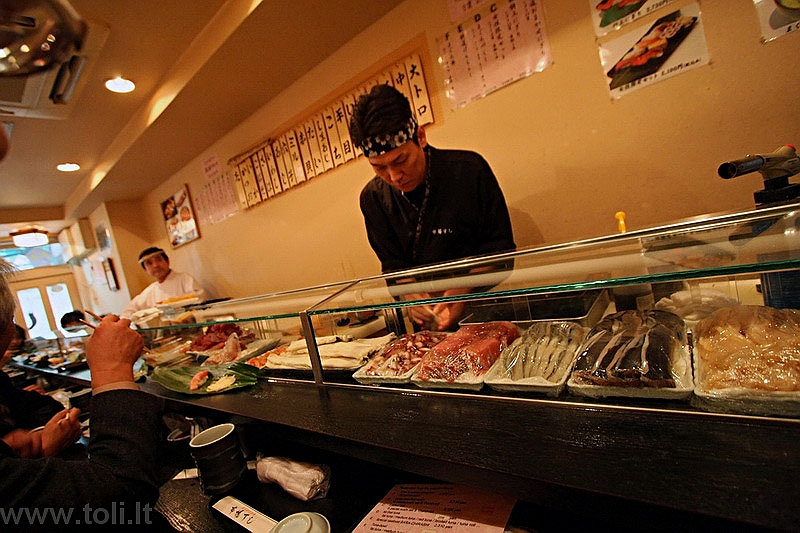 japonija004 Tokijas, Cukidži žuvų turgus. Mažyčio restoranėlio šefas lankytojų akivaizdoje iš šviežiausios žuvies ruošia suši